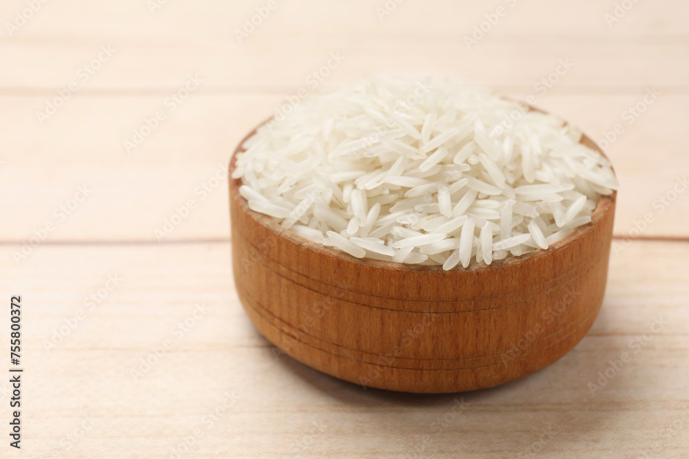 Raw basmati rice in bowl on white wooden table, closeup Raw basmati rice in bowl on white wooden table, closeup