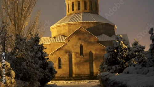 Beautiful Surb Sargis (Saint Sarkis) Armenian apostolic church covered with snow during a winter evening in Nor Nork district in Yerevan, with foreground trees, tilt up, uhd, 4k, 3840, 2160 photo