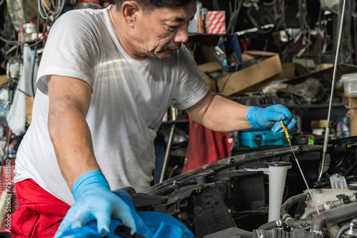 Expertise Asian auto mechanic man doing car repair and maintenance in auto garage