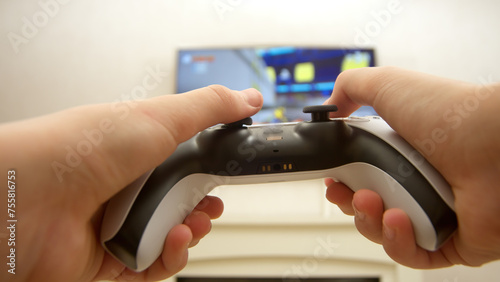 Close-up of a professional gamer's hands operating a PS controller. Home game console, modern technology, games, entertainment. photo
