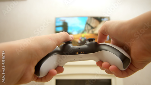 Close-up of a professional gamer's hands operating a PS controller. Home game console, modern technology, games, entertainment. photo