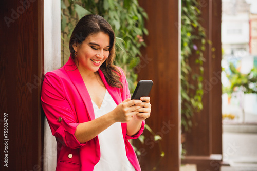 young woman writing on the cell phone next to a piece of wood