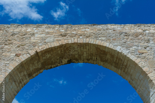 Obraz na płótnie low-angle view of an ancient aqueduct against a blue sky w salonie
