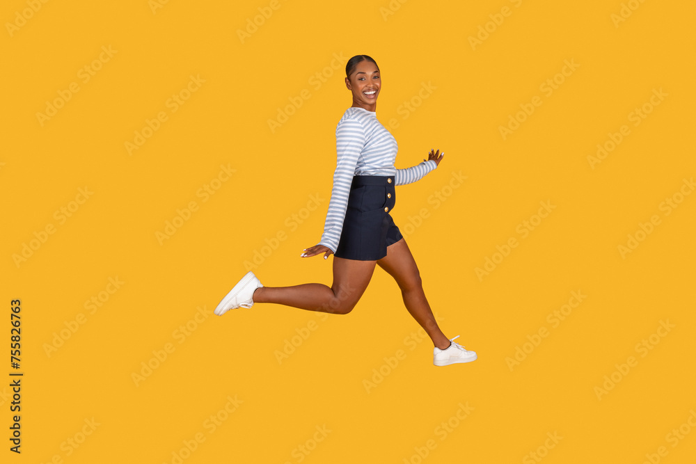 Happy young african american woman leaping in the air