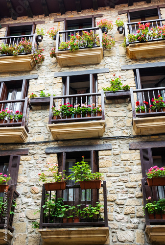 Colorful facades in town of Hondarribia  Spain. Balconies decorated with  flower pots. City environment details.