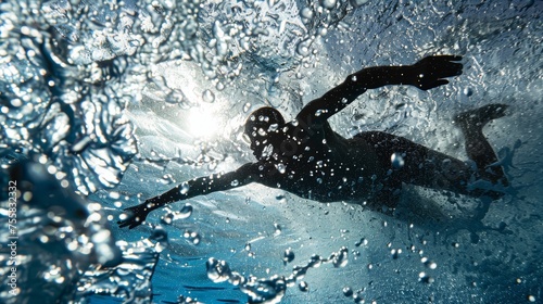 Swimmer's silhouette against sunlit water with bubbles. Competitive swimming and performance concept. Backlit underwater sports scene for poster and banner design © Tatyana