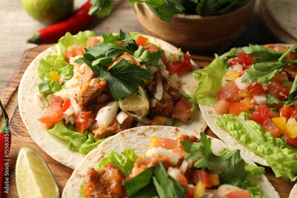 Delicious tacos with vegetables, meat and lime on table, closeup Delicious tacos with vegetables, meat and lime on table, closeup