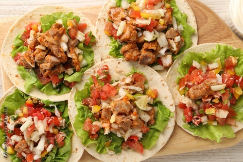 Delicious tacos with vegetables and meat on table, flat lay