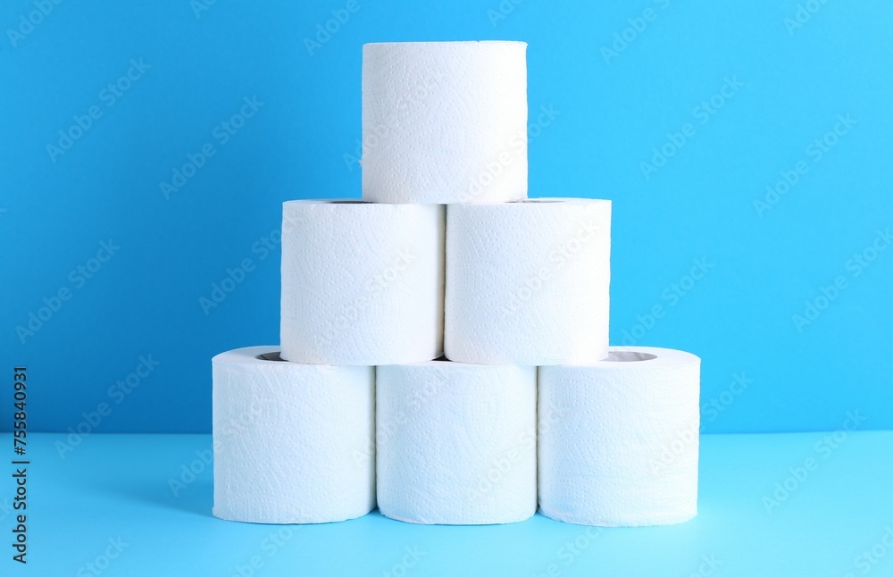 Pyramid of toilet paper rolls on light blue background Pyramid of toilet paper rolls on light blue background