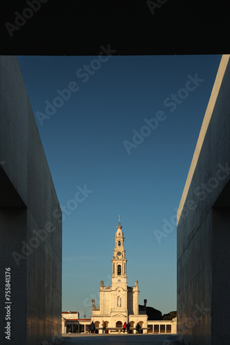 Fatima Sanctuary Church landmark building during a sunny sunset. Photo between the frames of this sanctuary building. Religious tourism in Portugal.