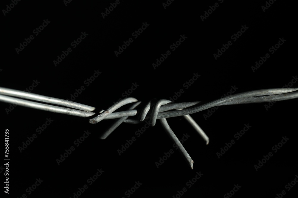 Metal barbed wire on black background, closeup Metal barbed wire on black background, closeup