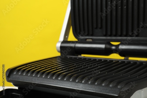 Electric grill on yellow background, closeup. Cooking appliance