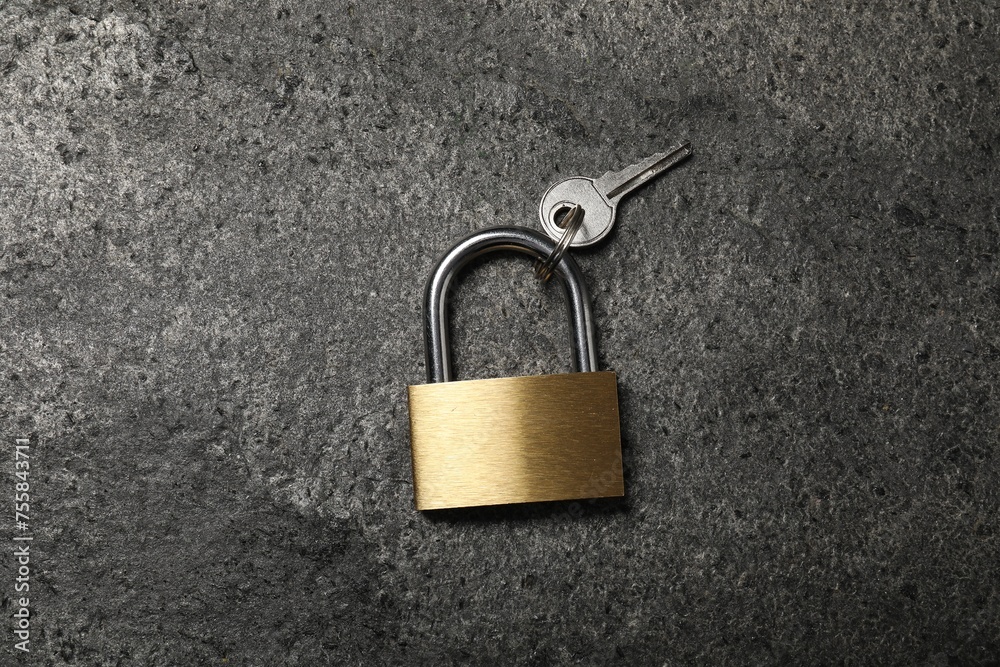 Fototapeta premium Steel padlock with key on grey table, top view