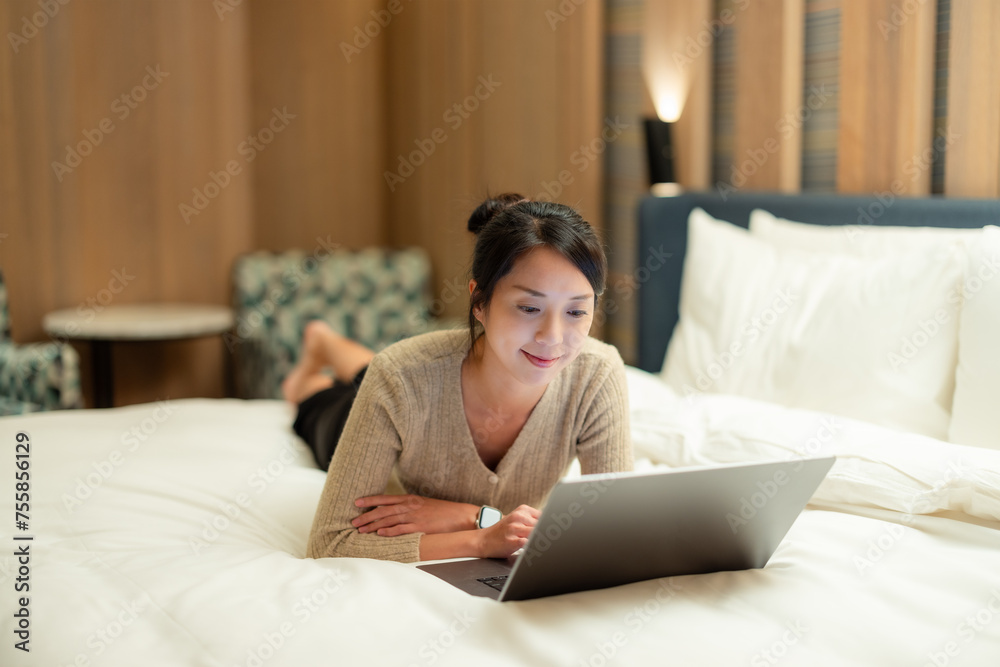 Woman watch on laptop computer and lying on bed at home Woman watch on laptop computer and lying on bed at home