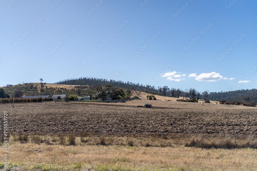 tractor plowing a field in a dry hot summer. farming landscape australia