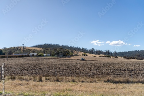 tractor plowing a field in a dry hot summer. farming landscape australia