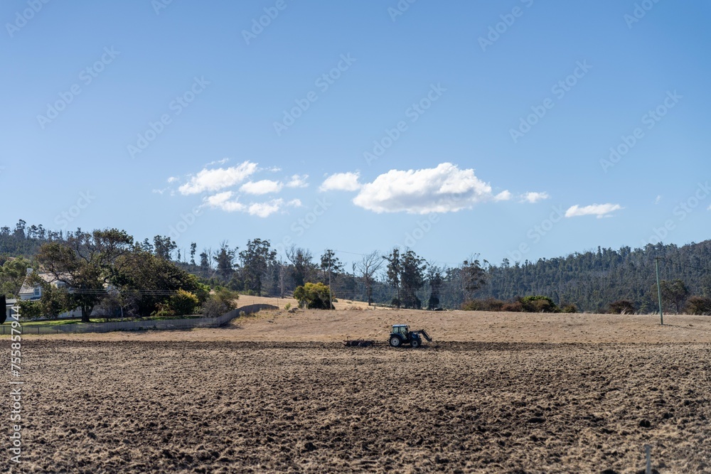 tractor plowing a field in a dry hot summer. farming landscape australia
