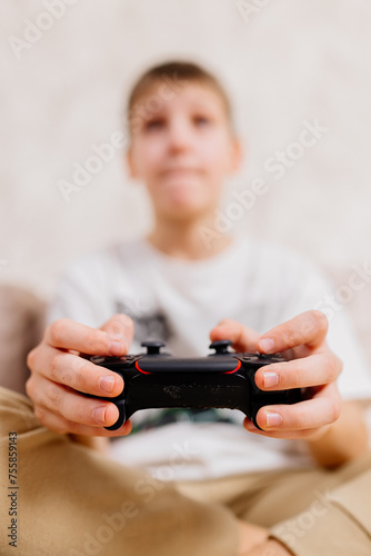 Close-up of a young gamer's hands operating a PS controller. Home game console, modern technology, games, entertainment.
