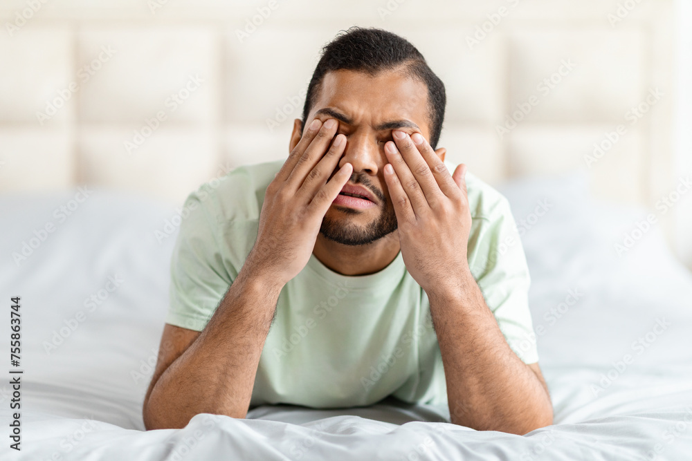 Upset broken african american young man crying in bed Upset broken african american young man crying in bed