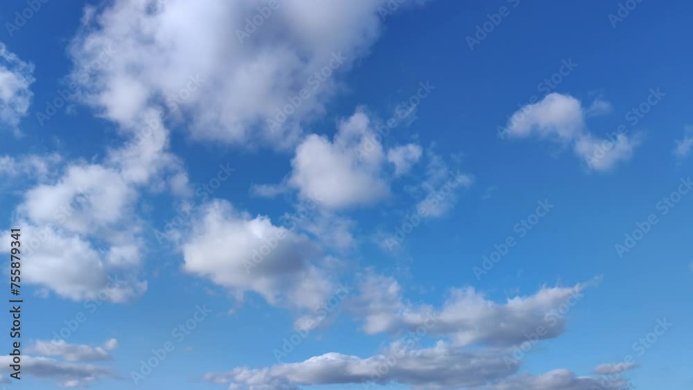 Small clusters of clouds move across the clear blue sky