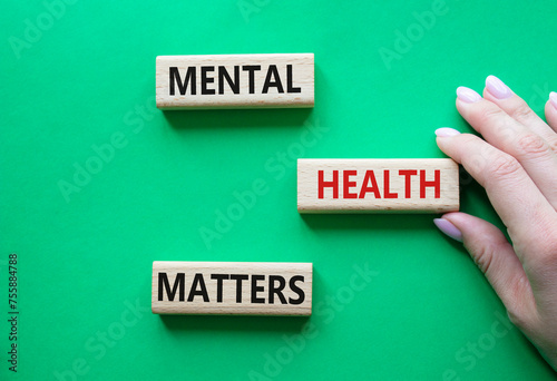 Mental Health Matters symbol. Concept words Mental Health Matters on wooden blocks. Beautiful green background. Doctor hand. Healthcare and Mental Health Matters concept. Copy space.