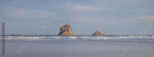 stone in the middle of the sea at sunset in sandfly bay in new zealand