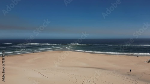 Aerial view - drone flight over a sand dune towards the ocean on a sunny day at Sardinia Bay Beach, South Africa - cinematic shot
