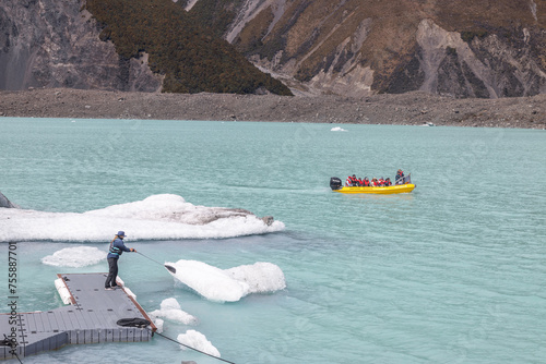 landscape of tasman glacier with boat arriving at jetty in new zealand in spring