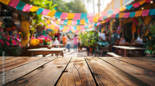 Empty wooden table with defocused decorated Mexican town, mockup scene for Cinco de Mayo holiday. © Maria Shchipakina