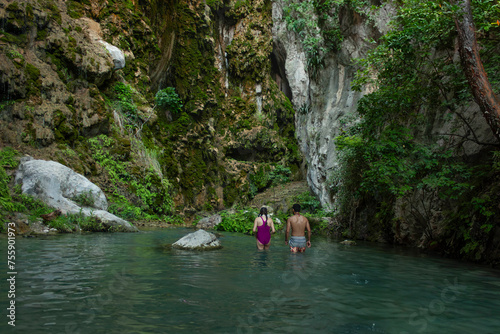 Man and woman heterosexual couple hiking healthy life style on ecotourism trip in Hidalgo, state of Mexico among the stalactites entering the grotto called La Gloria