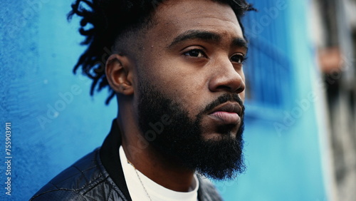 Bilde på lerret One pensive young black man standing in city street gazing with thoughtful expression