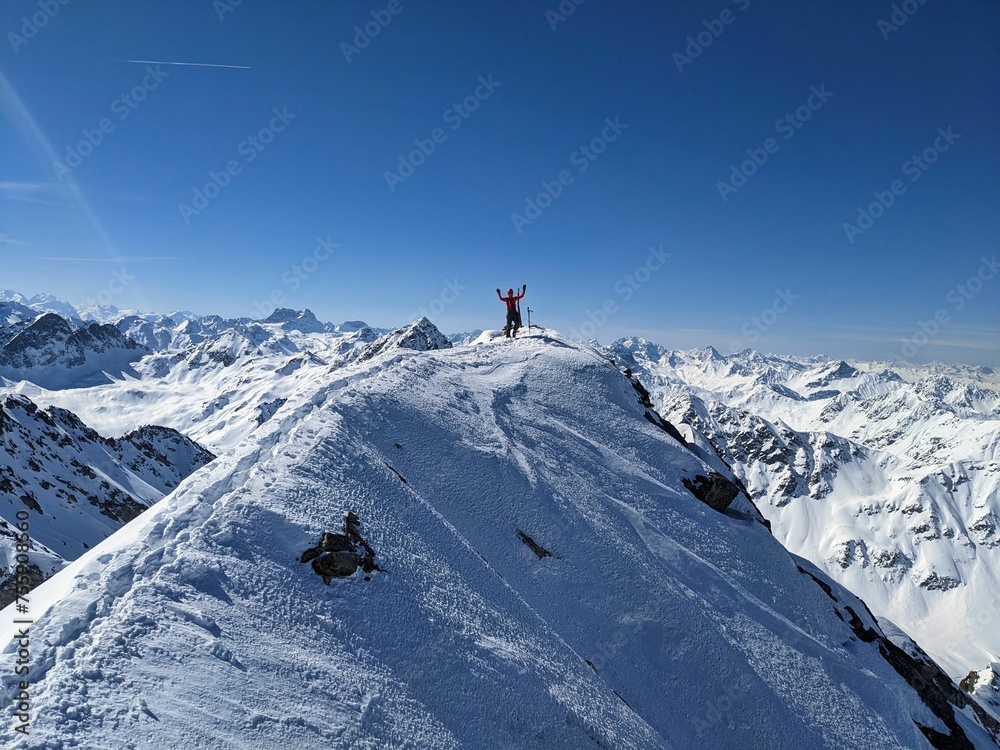 Mountaineers on the summit of the Flüela Wisshorn above Davos. Breathtaking views of the beautiful Swiss mountains.Ski mountaineering in winter. Summit ridge with snow. Enjoy life at the highest point