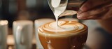 In a coffee shop, latte art pours milk into milk
