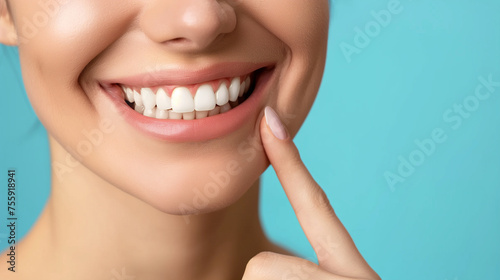 Dentistry, Woman with beautiful teeth. Close-up photo. Woman with beautiful teeth. Pointing finger at his own bright smile. Advertising image.
