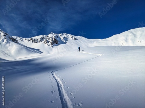 first line ski tour. Ski tourers fight their way through the untouched deep snow towards the summit. Büelenhorn Davos Monstein. Ski mountaineering in the Graubünden mountains. Ski track skitour. photo