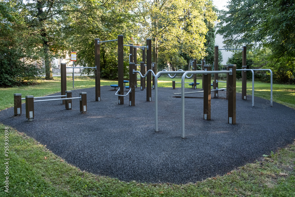 A sporty public playground featuring a horizontal slide, monkey bars