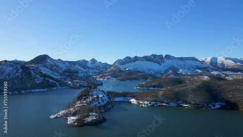 Vista por drones de un paisaje montañoso nevado con un hermoso lago. Embalse de Porma. Provincia: León, España photo