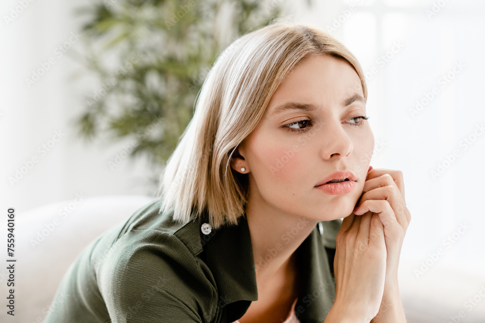 Pensive caucasian young woman thinking about sad things at home. Female contemplating, having nostalgia, thought about breakup, worried about future Pensive caucasian young woman thinking about sad things at home. Female contemplating, having nostalgia, thought about breakup, worried about future