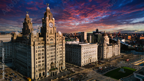 Aerial view of iconic Liverpool waterfront buildings at sunset with dramatic sky.