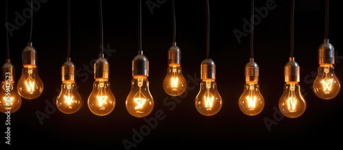 Close-up image of a string of illuminated light bulbs in darkness