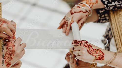 Mains de femmes tatouées au henné préparant la décoration du mariage photo