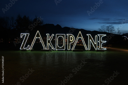 Wooden letters - landmark sign with the name of the city by night. Rowien Krupowa park, Zakopane, Poland.