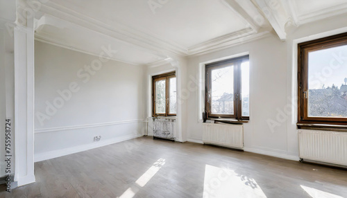 an empty room with wood flooring and white paint on the walls there is a large window in the corner. Copy space image. Place for adding text or design