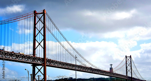 Fototapeta Naklejka Na Ścianę i Meble -  Panorama of Lisbon, April 25 Bridge and the statue of Jesus Christ. background of blue sky and blue clouds. Portugal during beautiful weather