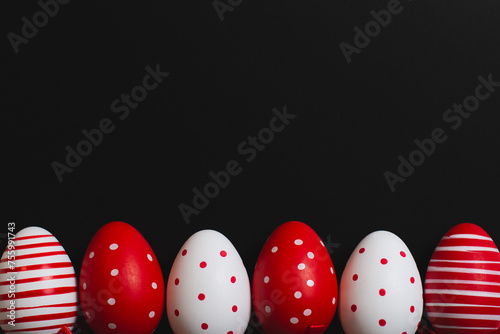 Red and white easter eggs on a black background. Space for text. 