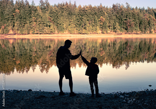 Father and son bonding in nature working together giving hight five. Parent child relationship concept. 