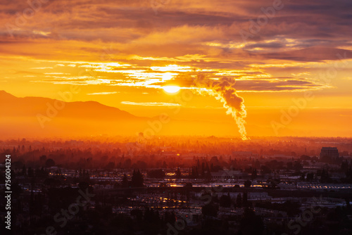 Industrial steam billowing into foggy sunrise above the San Fernando Valley in Los Angeles California.  