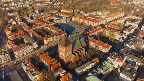 Aerial view of Koszalin city center during the "golden hour" with cathedral, Victory Street, and town hall.
