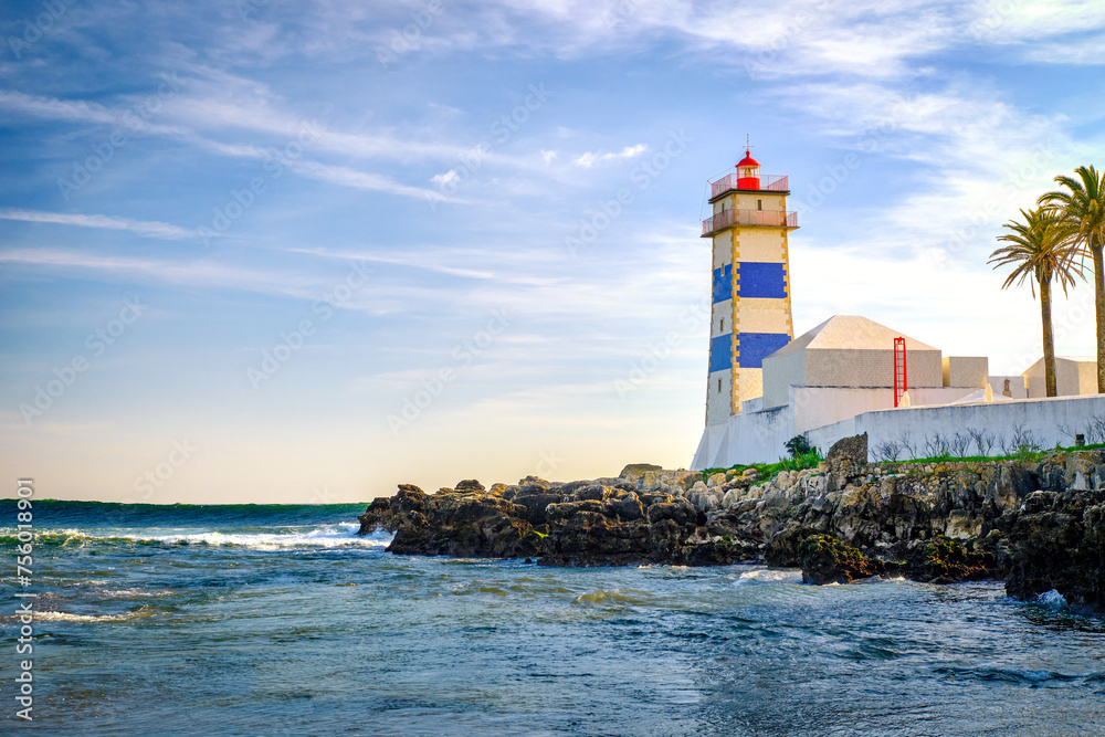 Beautiful evening, sea waves, rocky shores and lighthouse in Cascais