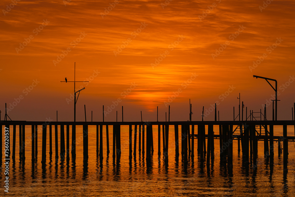 Alanya, Antalya, Türkiye, Turkey, Panoramic view of the old wooden pier standing on stilts in the water, orange cloudy sky, sunset, Mediterranean Sea in the background